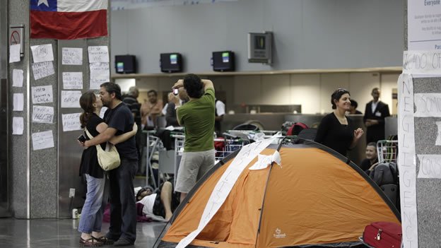 La cancelación de vuelos comerciales mantiene a muchos viajeros varados en el aeropuerto de Santiago. (Reuters).